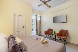 a living room with a bed and a flat screen tv at The Walnut Stays in Solan
