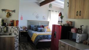 a bedroom with a bed and a kitchen with a refrigerator at The Little Cove in Vaal Marina