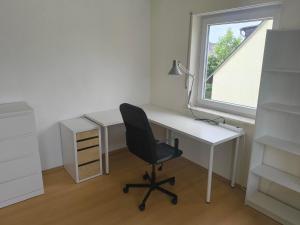 a white desk with a chair and a window at Inselappartement in Niederwerth