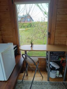 a table and a chair in a room with a window at Namelis Karklėje in Karklė