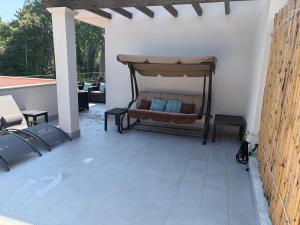 a porch with a bed and a couch on a patio at Lightblue in Marina di Massa