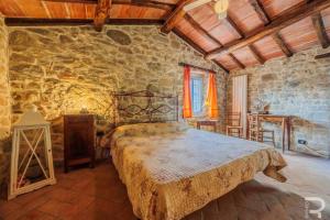 a bedroom with a bed and a stone wall at Tuscan house, exclusive pool, private garden in Bagni di Lucca +29 photos