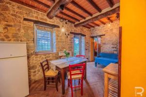 a kitchen with a table and chairs and a refrigerator at Tuscan house, exclusive pool, private garden in Bagni di Lucca