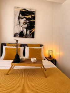 a bedroom with a bed with a painting on the wall at Yellow Apartment in Floreşti