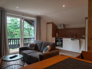 a living room with a couch and a large window at Wellness Pension Hubertus in Marquartstein