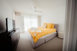 a bedroom with a bed with a yellow blanket at Coastal on Clarke in Portarlington