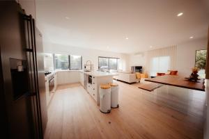 a kitchen and living room with white cabinets and a table at Coastal on Clarke in Portarlington