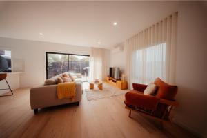 a living room with a couch and two chairs at Coastal on Clarke in Portarlington
