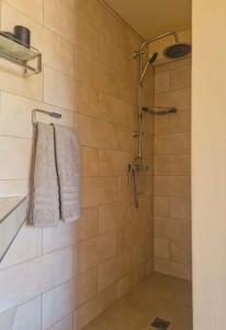 a shower with two towels hanging on a wall at B&B The Protea in Zonnebeke