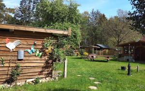 a backyard with a chicken on the side of a house at Tiny house im Wingster Forst in Wingst