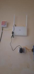 a white monitor on a wall next to a charger at Banaras Apartment Homestay 7BHK AC & NON AC ROOMS in KASHI VISHWANATH JYOTIRLING in Varanasi