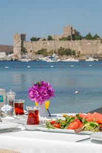 a table with a plate of food and flowers on it at Artemis Hotel in Bodrum City +32 photos