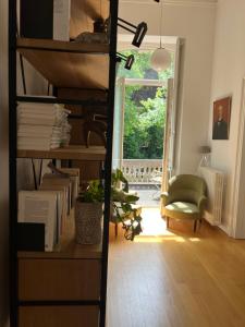 a room with a book shelf with books and a chair at Chez Léopold II in Verviers