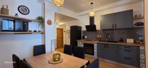 a kitchen and dining room with a table and chairs at La Maison Douce Lourdes in Lourdes