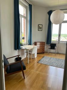a living room with a table and blue curtains at Chez Léopold II in Verviers