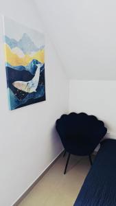 a bedroom with a chair and a painting on the wall at Villa Henry in Grzybowo