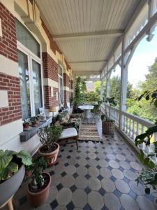 a porch with potted plants on a building at Chez Léopold II in Verviers
