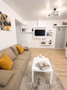 a living room with a couch and a coffee table at Yellow Apartment in Floreşti