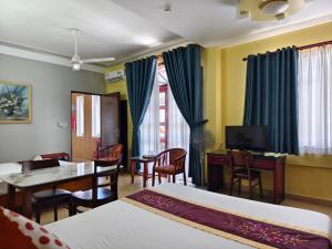 a hotel room with two beds and a table and chairs at Sunny C Hotel in Hue