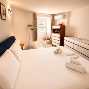 a bedroom with a large white bed with towels on it at Tra i laghi lago maggiore e lago d'orta in Invorio Inferiore