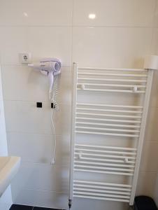 a white shower stall with a hair dryer on the wall at Pension Valentina in Mühlau +58 photos