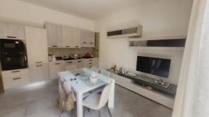 a kitchen with a white table and a white table and chairs at L'Officina in Leverano