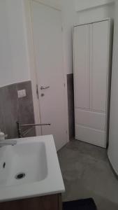 a bathroom with a white sink and a door at L'Officina in Leverano +21 photos