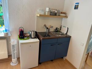 a small kitchen with a sink and a counter at Gemütliche Ferienwohnung nähe Schloss Benrath & Rhein Düsseldorf Urdenbach in Düsseldorf +6 photos