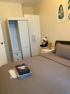 a bedroom with a bed with a book and a panda bear at 45ft Floor with Fast Wi-Fi Pool & Gym Access in Manila +16 photos