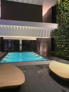 a swimming pool in a building with two benches at 45ft Floor with Fast Wi-Fi Pool & Gym Access in Manila