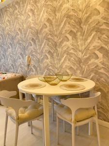 a white table with chairs and bowls on top at 45ft Floor with Fast Wi-Fi Pool & Gym Access in Manila