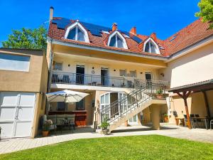 a house with a patio and a balcony at Weinberger Vendégház in Zamárdi