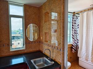 a kitchen with a sink and a mirror and a window at Sunny C Hotel in Hue +28 photos