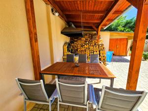 a table and chairs in a patio with a stove at Weinberger Vendégház in Zamárdi