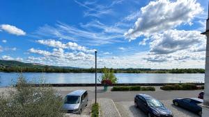 two cars parked in a parking lot next to a river at Riverside Ybbs - Danube View in Ybbs an der Donau