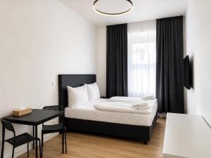 a bedroom with a bed and a table and a window at Figaro Suites in Prague