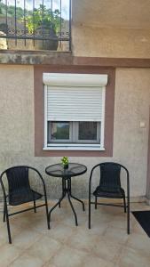 two chairs and a table in front of a window at Aura Bay Cozy Studio in Kotor