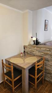 a wooden table with two chairs in a room at Aura Bay Cozy Studio in Kotor