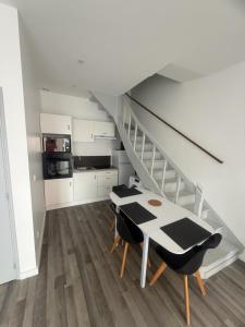 a kitchen with a table and chairs and a staircase at Maison campagne proche A75 in Vergongheon