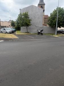 a motorcycle parked in a parking lot next to a building at Maison campagne proche A75 in Vergongheon