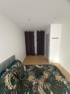 a bedroom with a bed with a colorful blanket at Maison campagne proche A75 in Vergongheon