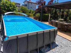 a large swimming pool in a backyard with a table at Mulberry Suites in Paralia Dionysiou