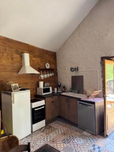 a kitchen with a white refrigerator and a stove at La grange de Jean et Claude in Barre-des-Cévennes