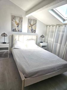 a bedroom with a white bed with two lamps at maison cosy pour 4 à 5 personnes 10mns des plages in Sanary-sur-Mer