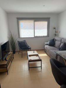 a living room with a couch and a table at Casa Golf Mar Menor in Los Martínez