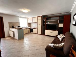 a living room with a couch and a kitchen at Locazione Turistica Antonella in Fiumicino