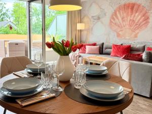 a dining room with a table with plates and glasses at Wahlheimat Haffkrug, Strandnaher Ostseeurlaub, Terrasse, Tiefgarage und WLAN in Scharbeutz