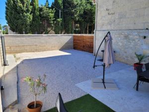 a patio with a umbrella on a stand next to a wall at Appartement dans Mas Provencal in Arles