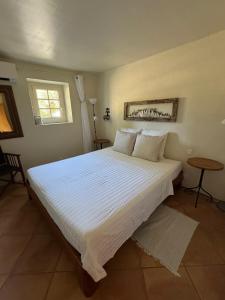 a large white bed in a bedroom with a window at Domaine de Villedese in Montlaur +30 photos