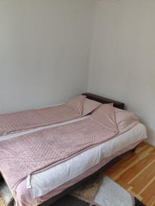 a bed with pink sheets in a bedroom at Apartment Victoria in Foča